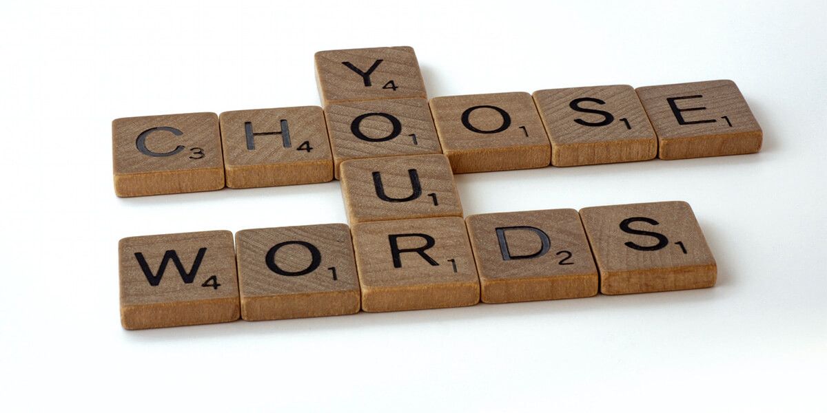 Auf dem Bild sieht man einzelne Buchstaben wie bei Scrabble. Aus Holz. Man liest "CHOOSE YOUR WORDS"