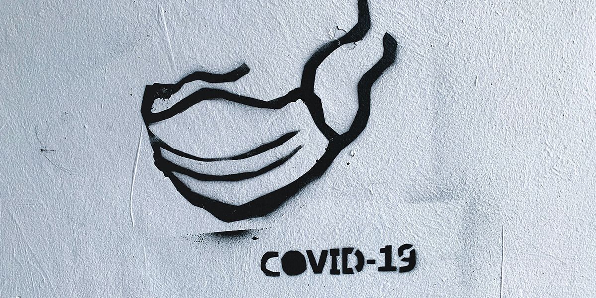 Das Bild zeigt eine COVID-19 Maske. Schwarz auf weissem Hintergrund